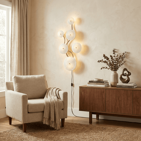 The vertical version lit beside a cream armchair, its cord running to the floor