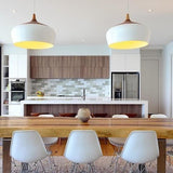 White domes lit above a kitchen counter with stools