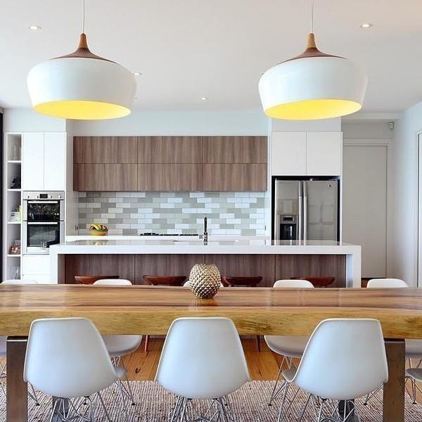 White domes lit above a kitchen counter with stools