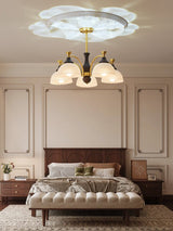 Domes lit above a made bed in a room with wall panels behind it