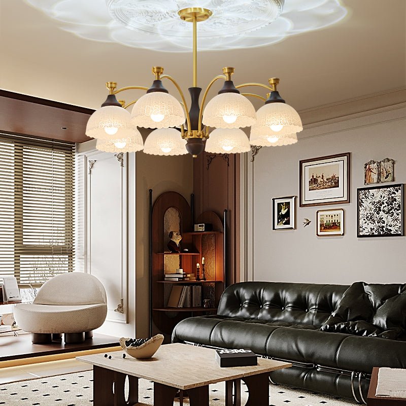 Chandelier lit in a living room above a dark leather sofa and table