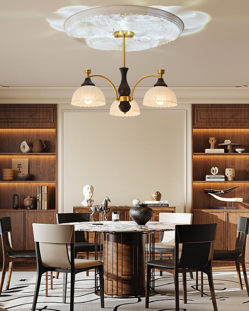 The fitting lit above a round dining table with dark chairs