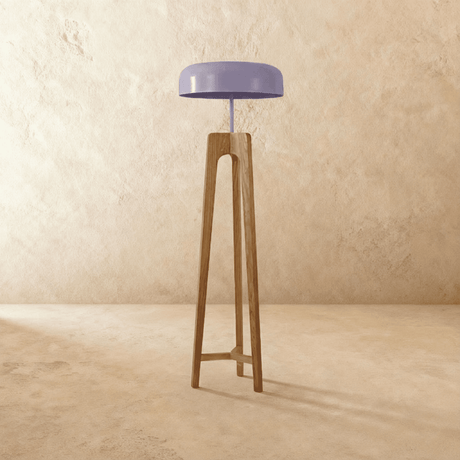 The light wood tripod with its pale dome shade unlit, legs braced in a triangle
