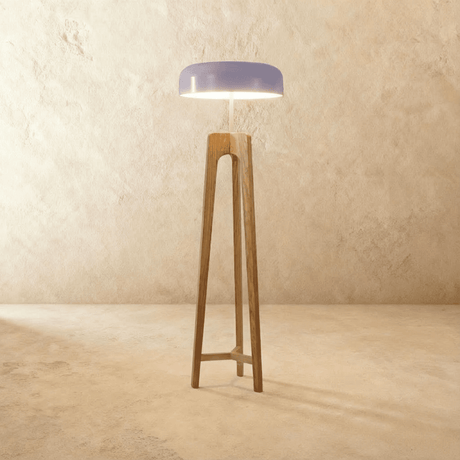 The same tripod in light wood with a pale dome shade lit from underneath