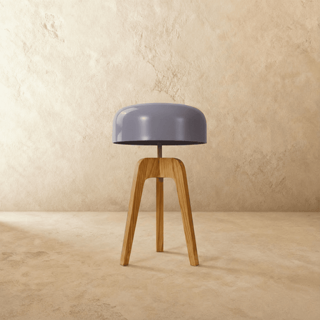 The short version in light wood unlit, the pale dome resting on the tripod top