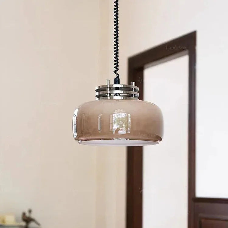 The amber glass dome lit on a twisted cord beside a wooden doorway