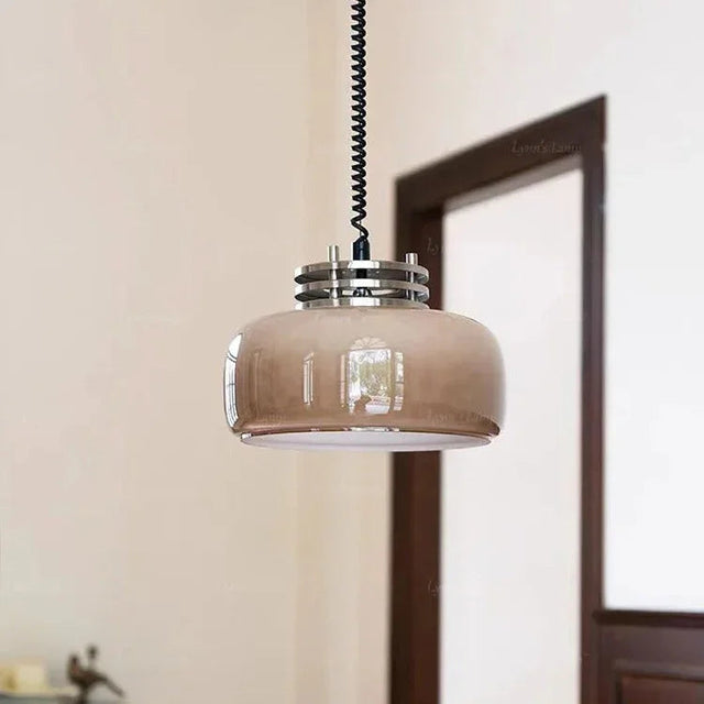 The amber glass dome lit on a twisted cord beside a wooden doorway