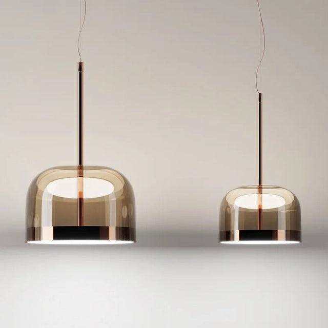Dome pendant light in tinted glass hung in a row above a counter