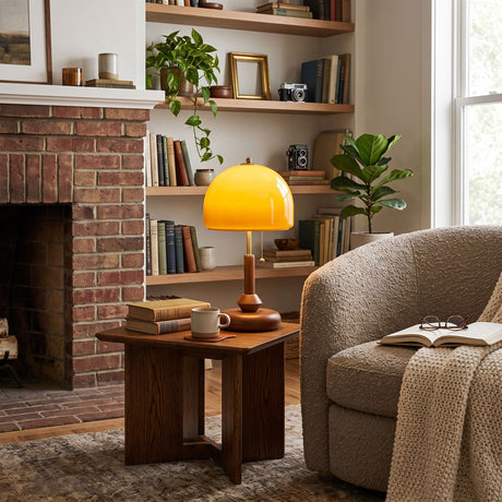 Amber dome table lamp lit on a side table beside a brick fireplace