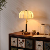 Segmented dome lamp lit on a console in a room with pale walls