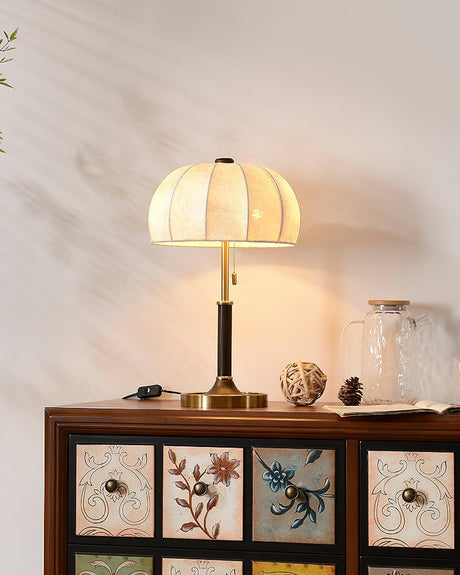 Segmented dome lamp lit on a painted cabinet with floral drawer fronts