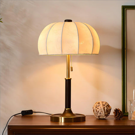 Segmented dome lamp lit on a sideboard beside a framed print