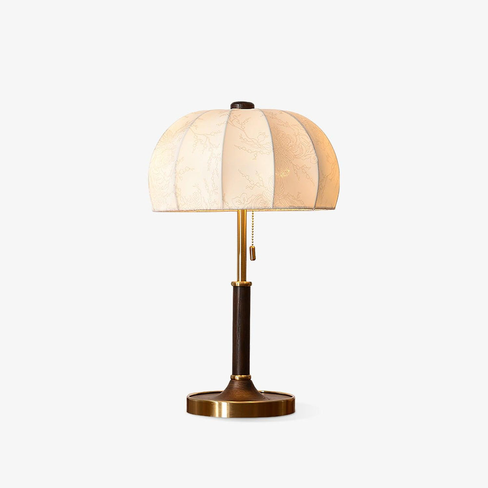 Table lamp with a segmented linen dome shade on a slim stem and brass foot