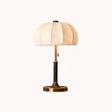 Segmented dome lamp with a walnut and gold stem on a plain ground