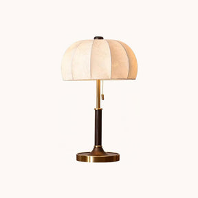 Segmented dome lamp with a walnut and gold stem on a plain ground