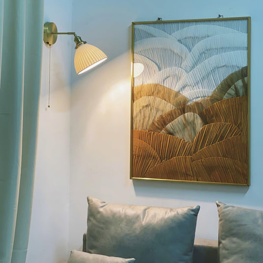 The sconce beside a large framed painting above a sofa with teal cushions