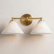 The brass version with two stone cone shades, seen on a pale wall