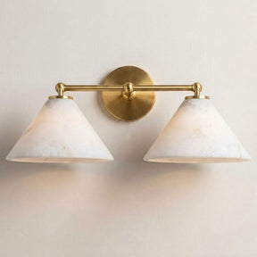 The brass version with two stone cone shades, seen on a pale wall
