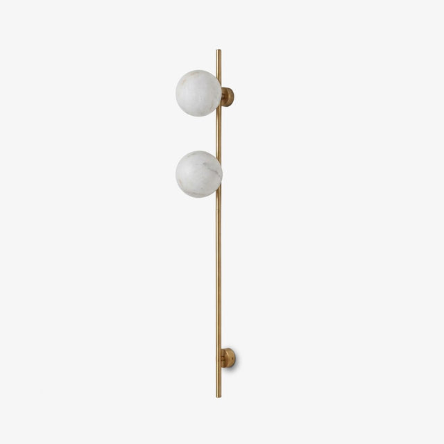 Tall slim rod wall sconce with two round stone globes on a pale wall