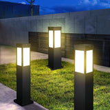 Three lit on grass beside a paved walk with a slate wall behind