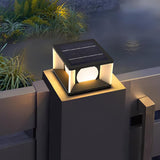 The cube lit on a concrete pillar with ornamental grasses beside it