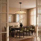 A lit stone drum above a dining table set with green chairs
