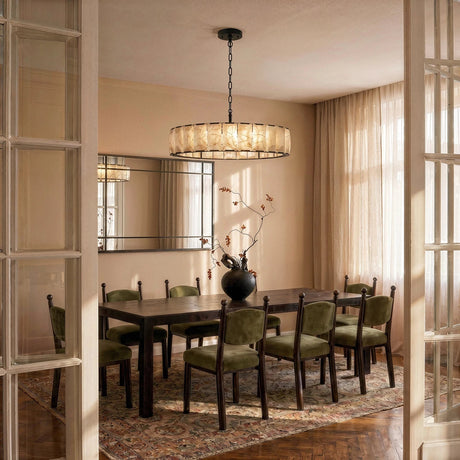 A lit stone drum above a dining table set with green chairs