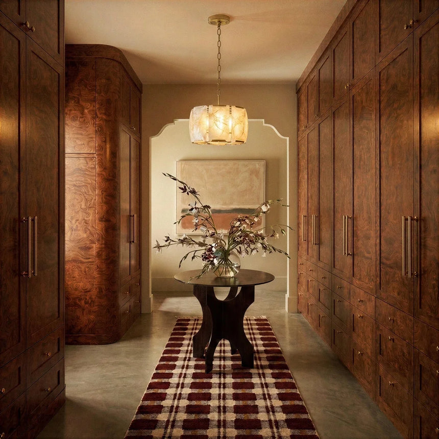 A lit drum in a hallway between timber wardrobes above a rug