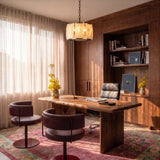 A lit stone drum above a timber desk and two chairs in an office