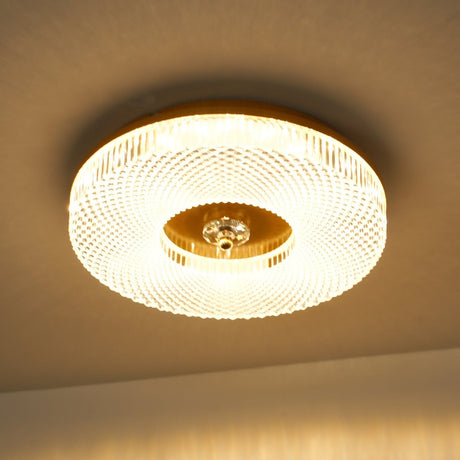 Lit ribbed drum ceiling light seen close against a warm ceiling