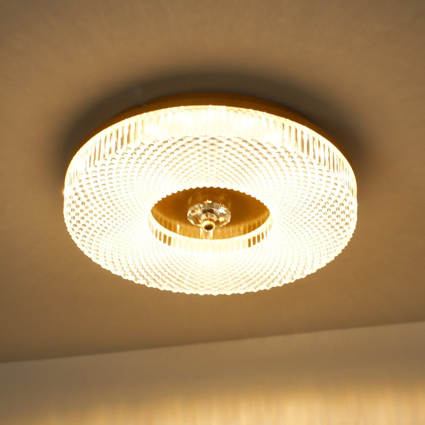 Lit ribbed drum ceiling light seen close against a warm ceiling