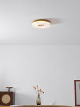 Ribbed drum ceiling light on a white ceiling above a sideboard