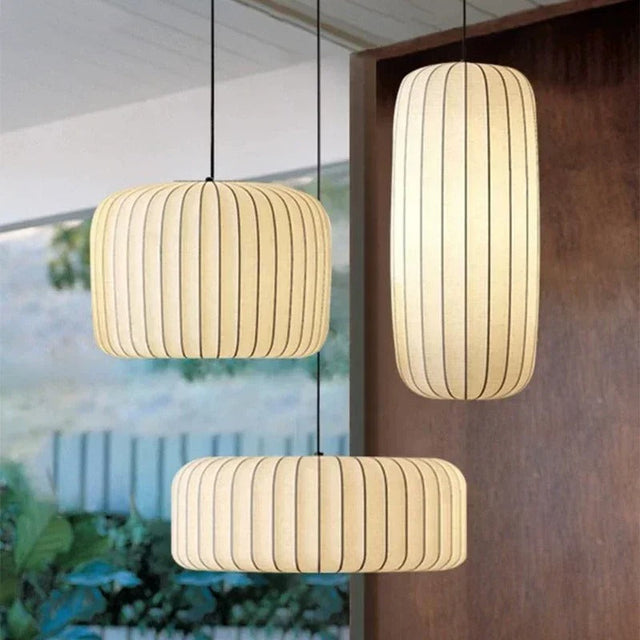 Drum pendant lamp in ribbed silk, three shades hung together in a bright room