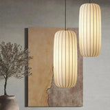 Slim silk column hung beside a framed artwork and a dried branch