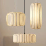 Pair of ribbed silk shades hung at different heights against a pale wall