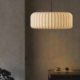 Wide ribbed silk drum lit above a table in a warm interior