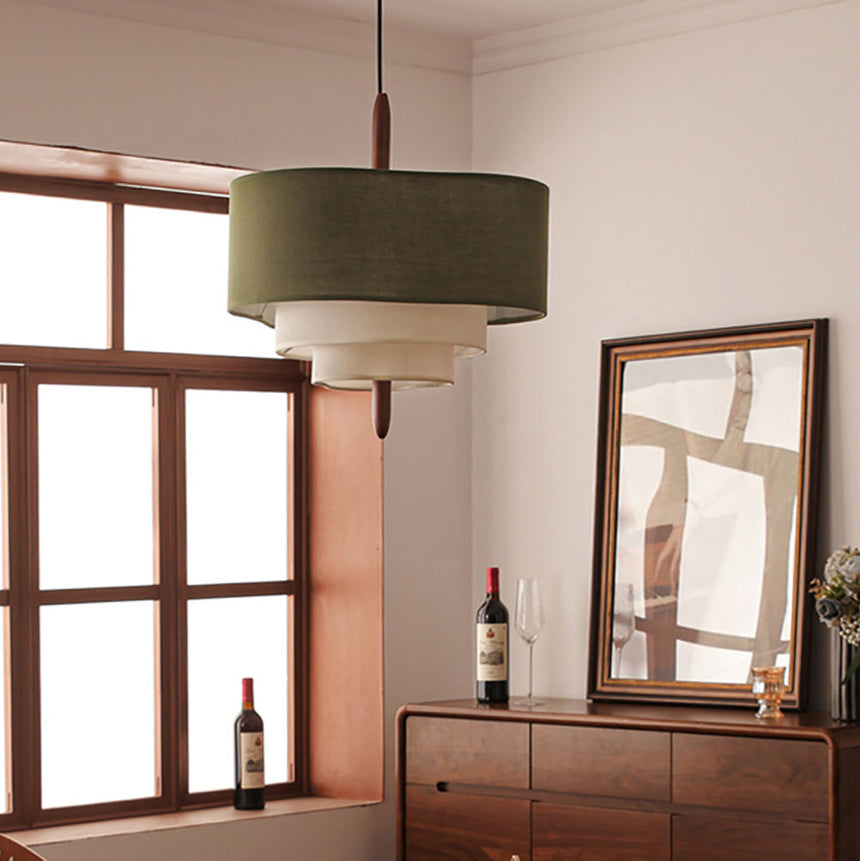Tiered drum shade hung beside a window with a dark wood cabinet below