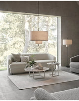 Drum shade pendant light in a living room beside a window seat