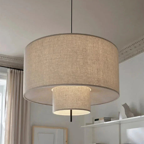 Close view of the woven oatmeal fabric and the dark rim of the drum shade
