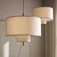 Drum shade pendant light in woven fabric, two hung at different heights