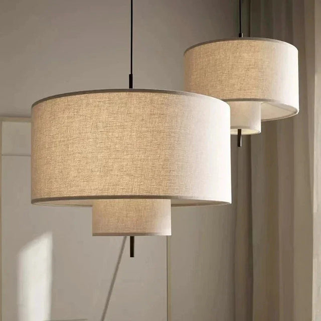 Drum shade pendant light in woven fabric, two hung at different heights