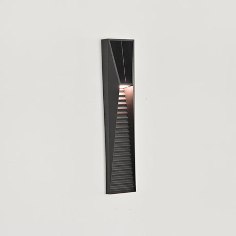The light lit and seen from the side on a white wall, the louvers catching the glow