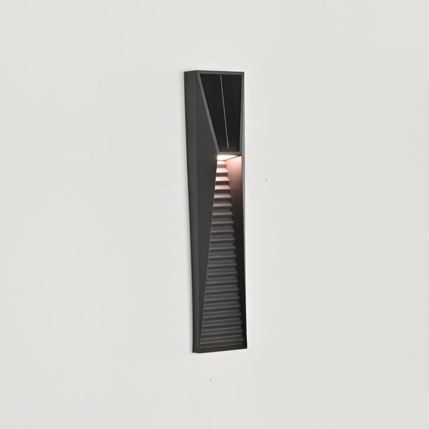 The light lit and seen from the side on a white wall, the louvers catching the glow