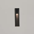 The short size lit on a pale wall, the warm band under the solar cell