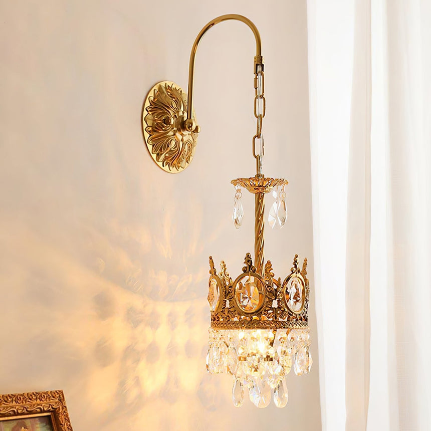 The sconce lit beside a sheer curtain, the crystals scattering light on the wall