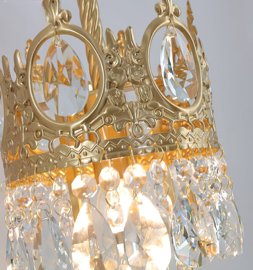 Close view of the pierced gold crown and the crystal drops below it