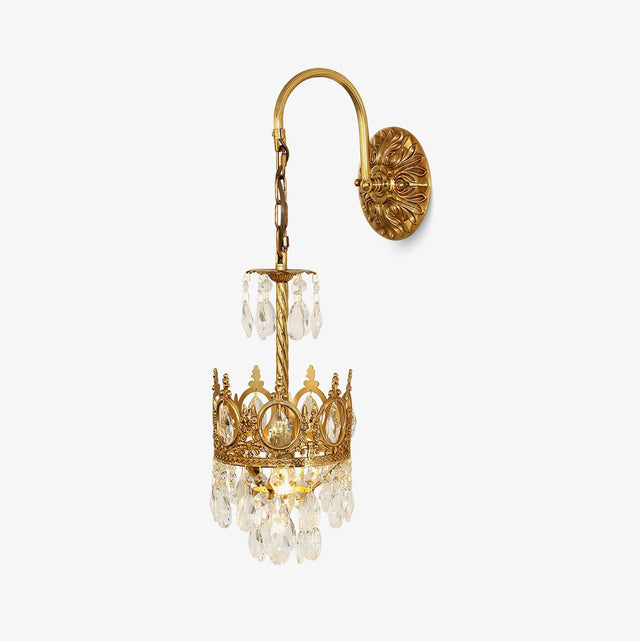 Gold tone wall sconce with a curved arm, a chain and a small crown of hanging crystals