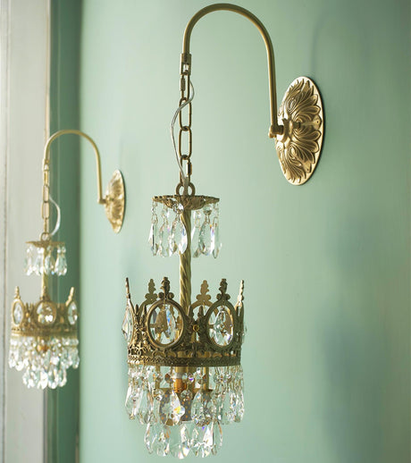 The small and large sizes lit side by side on a mint green wall