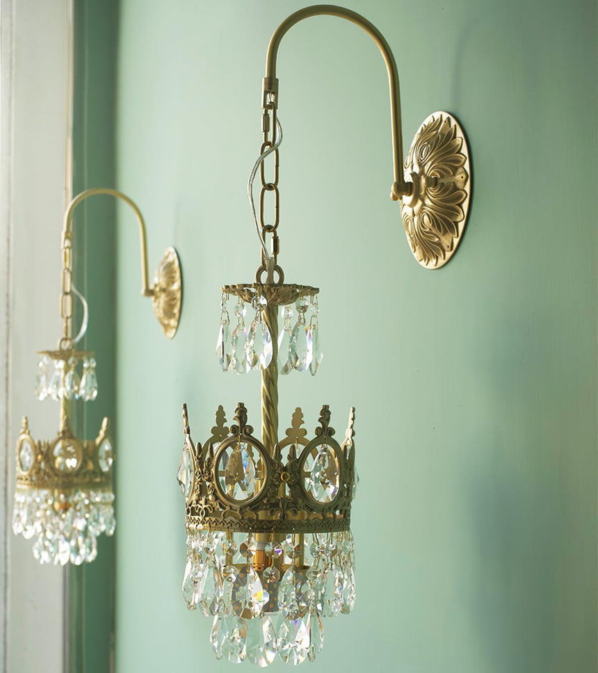 The small and large sizes lit side by side on a mint green wall