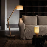 Entryway table lamp lit on a side table beside a pale sofa
